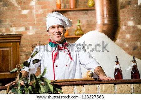 portrait of a cook, is on the traditional kitchen relies hands on the table