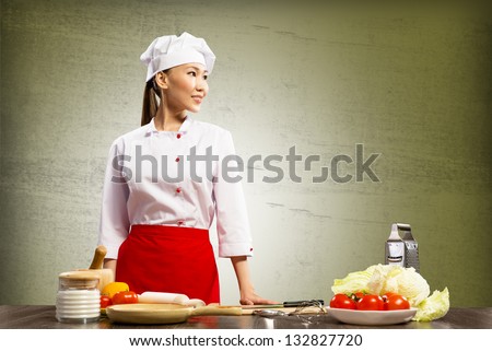 Asian female chef looking at the space for text