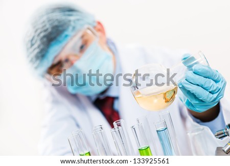 scientist working in the lab examines a test tube with liquid