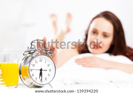 woman turns off the alarm and wake up smiling and happy