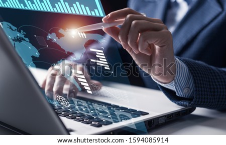 Businessman works with financial data. Futuristic 3d interface above laptop computer. Interactive financial diagrams and digital data visualization concept. Global e-business network communication ストックフォト © 