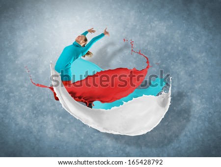 female dancer jumped surrounded by splashes of paint
