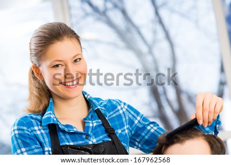 close portrait of a woman barber, hair puts the customer in the barbershop