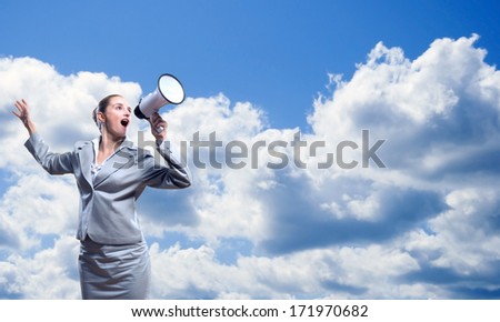 business woman cooks shouting into a megaphone behind blue sky with clouds