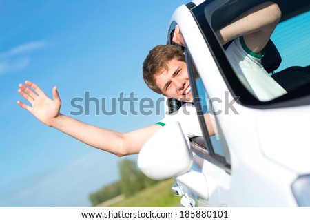 young man stuck his hand out of the window of the car, country car trip