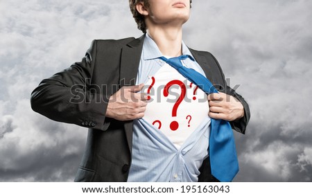 businessman breaks the shirt, under which the question marks behind the clouds background