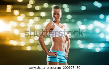 Sport woman in shorts and top exercising at stadium