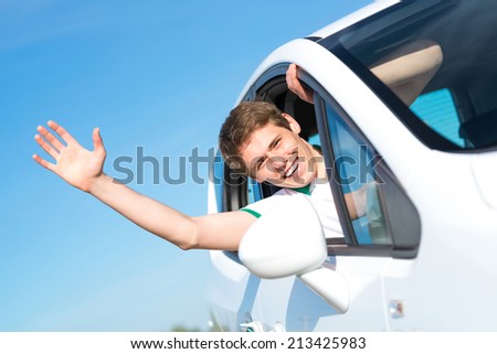 young man stuck his hand out of the window of the car, country car trip