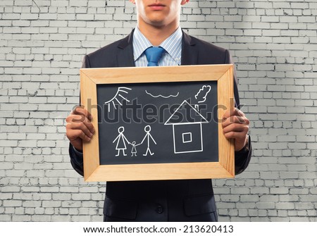Close up of businessman holding chalkboard with family sketches