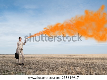 Young businesswoman with suitcase using spray balloon