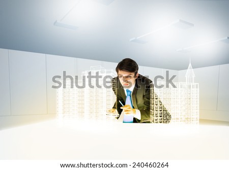 Young businessman and digital model of construction project
