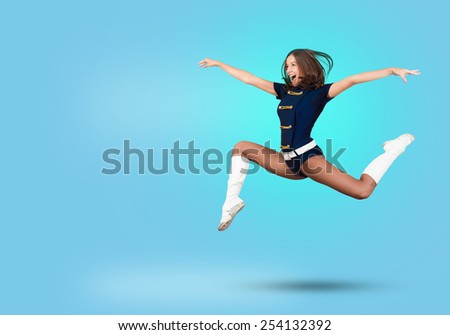 Young beautiful smiling cheerleader girl jumping high