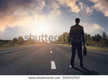 Businessman goes straight on his way on asphalt road