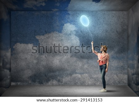 Young woman in casual holding bulb balloon