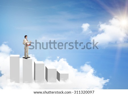 Young businessman standing on graph bars and playing drums