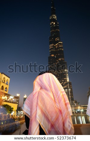 DUBAI - MARCH 31:Arab Man watching Dubai Fountain at Burj Khalifa, Long exposure technique create a little of natural blur motion. 31 march 2010 in dubai, UAE