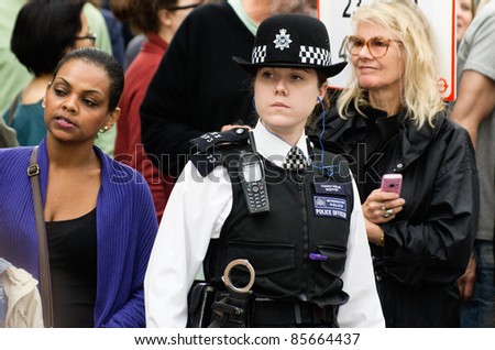 LONDON - AUG 28: policewoman patrols the street of  Notting Hill during the famous annual caribbean  Carnival on August 29, 2011 in London, England.