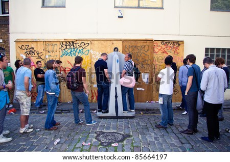 LONDON - AUG 28: men queue up at a open-sky toilet during the  Notting Hill Carnival on August 29, 2011 in London, England.
