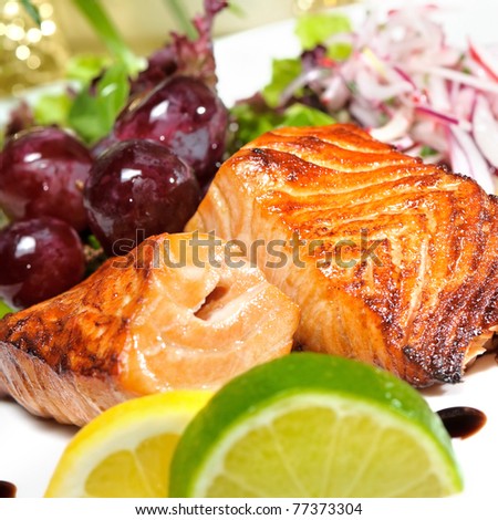 piece of grilled salmon, lettuce and lemon,grapes