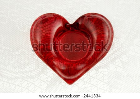 Red glass heart on white lace with space in center for text