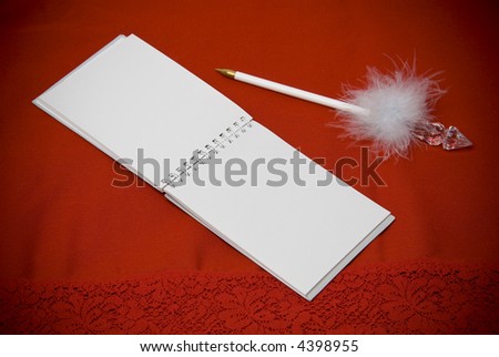 vignetted horizontal view of open notepad with white pen laying next to it