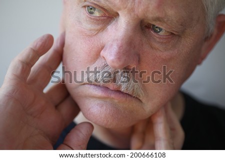 Man with fingers on painful jaw