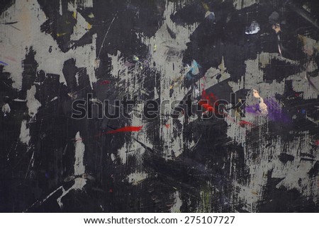 Gray surface with predominately black paint and small areas of brighter colors