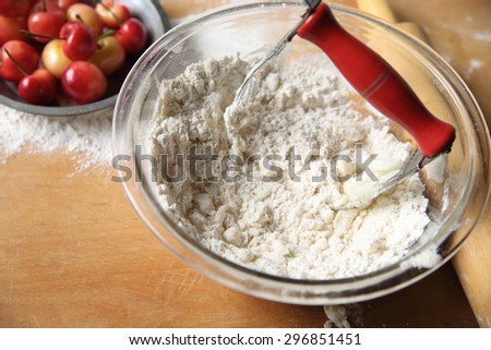 Cutting butter into flour to make pastry crust for cherry pie, copy space included