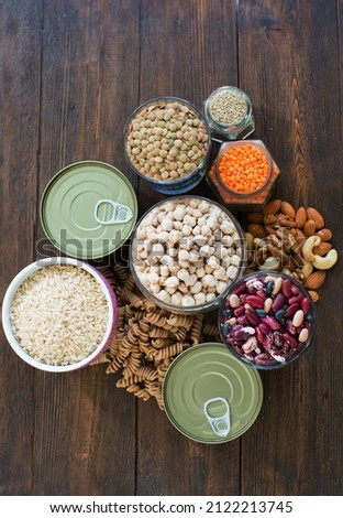 Non-perishable food, canned goods frame. Pasta, lentils,rice,nuts,quinoa,beans, chickpea and canned foods on a wooden background 商業照片 © 