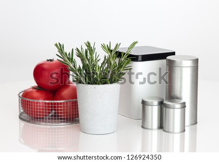 Food storage containers, tomatoes and rosemary on white background.