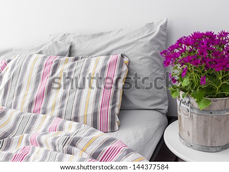 Modern bedroom decorated with bright purple flowers. Fresh design.