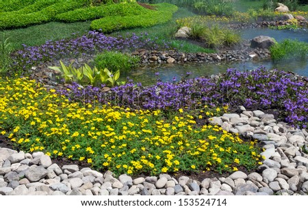 Beautifully landscaped summer garden with flowers, stones and water.