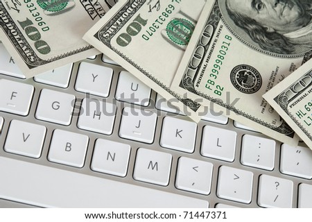 US hundred dollar bills on white modern computer keyboard.