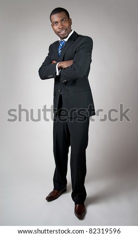African American businessman standing with his arms crossed, smiling.
