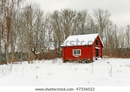 Traditional Swedish red wooden house covered by snow. Scandinavian winter.