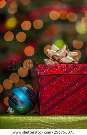 Christmas gift boxes and ornaments under a tree with defocused lights