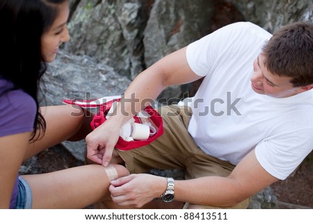 Young man putting band aid on a young woman