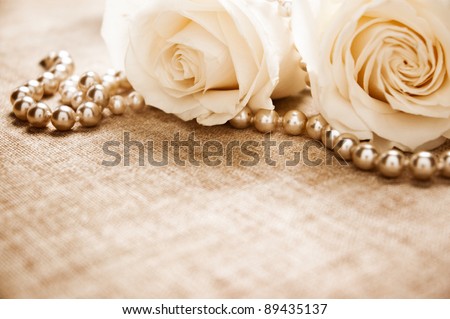 White roses and pearls on an antique book cover