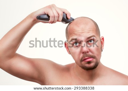a man shaves his head