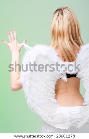 young woman with white angel wings on a green background.