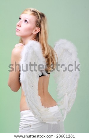 Attractive woman with white angel wings on a green background.