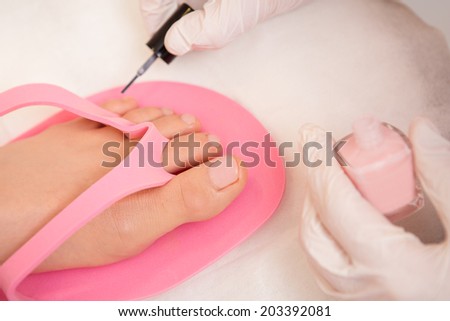 Close-up Of A Beautician Applying Nail Varnish To Woman\'s Feet