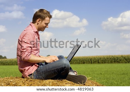 handosme man with laptop over country view.