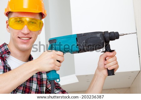 smiling repairman with electric drill