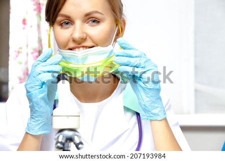 young woman  researcher holding in hands goggles, smiling and looking into the lens