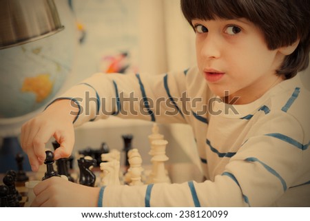young chess player, the boy with the figures in the hands near the chessboard, instagram filter style