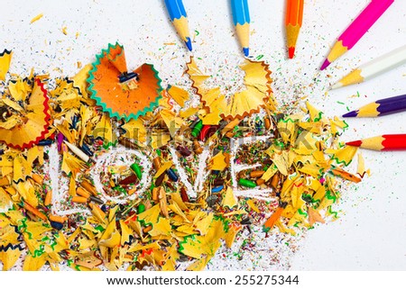 The word love on the background of colored pencil shavings