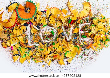 The word Love on the white background of colored pencil shavings