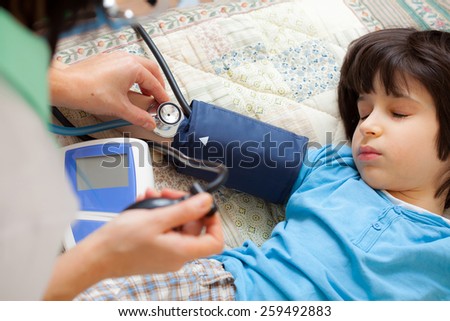 family doctor measures the blood pressure of boy