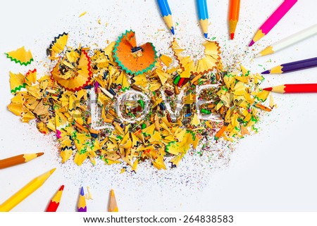 The word LOVE on the background from colored pencil shavings